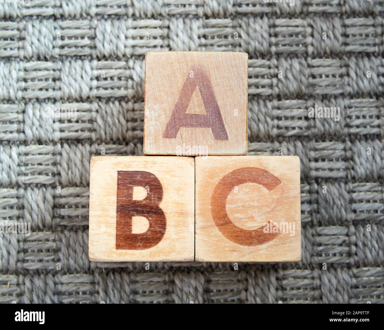 Wooden alphabet blocks spelling abc sur moquette grise. Jouets éducatifs pour les enfants en école maternelle. Banque D'Images