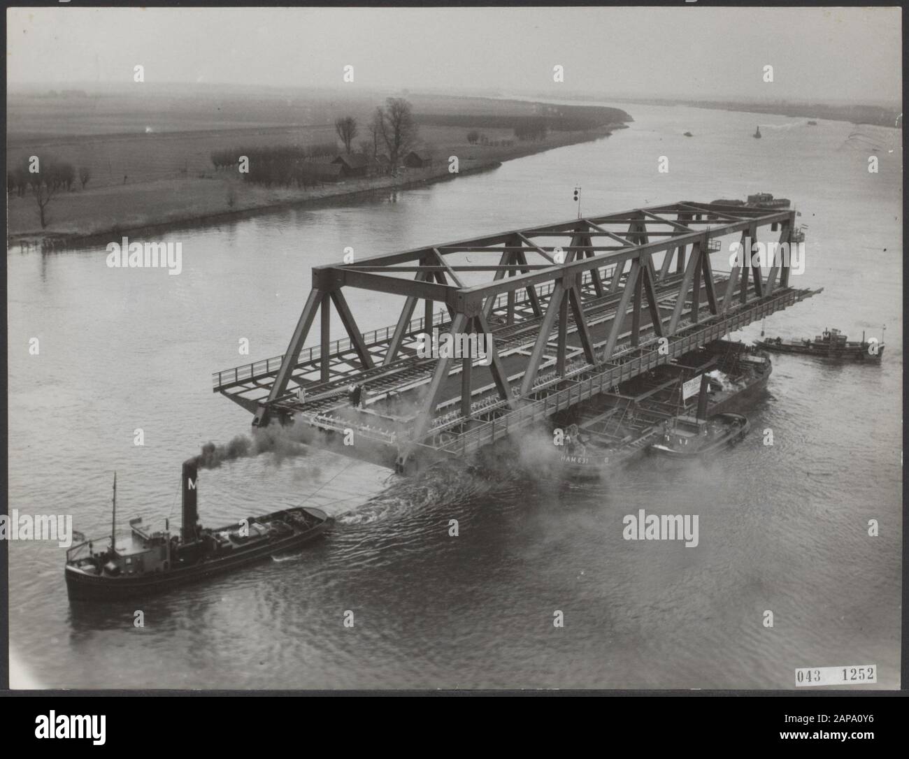 La première arche devant le pont au-dessus de l'Oude Maas près de Pernis a été traînée mardi de Dordrecht à Pernis et y a apporté à sa place. La longueur de cette arche est de 80,10 mètres et mesure 22 mètres de large et la hauteur est de 12 mètres. Image du transport dans l'Oude Maas du pont élévateur à Spijkenisse Date: 16 mars 1954 lieu: Dordrecht, Oude Maas, Pernis, Spijkenisse, Zuid-Holland mots clés: Ponts, rivières, navires, transports Banque D'Images