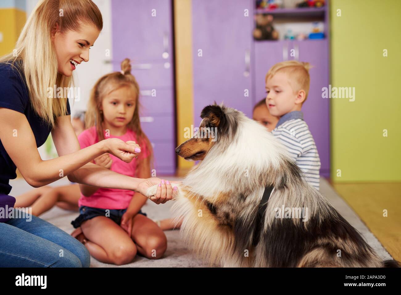 Thérapeute féminin et son chien dans la maternelle Banque D'Images