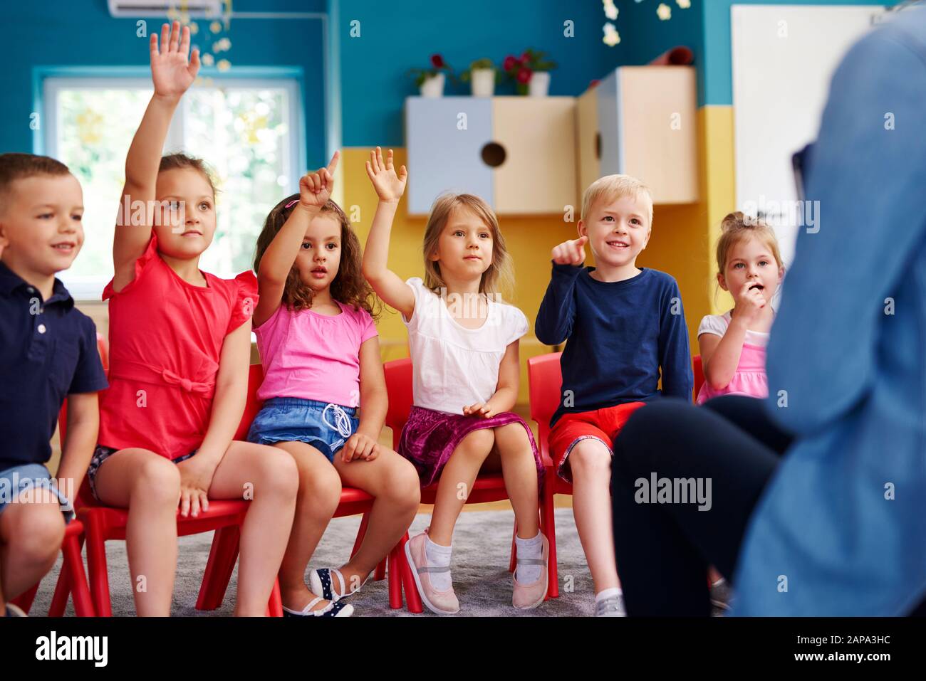 Groupe d'enfants d'âge préscolaire répondant à une question Banque D'Images