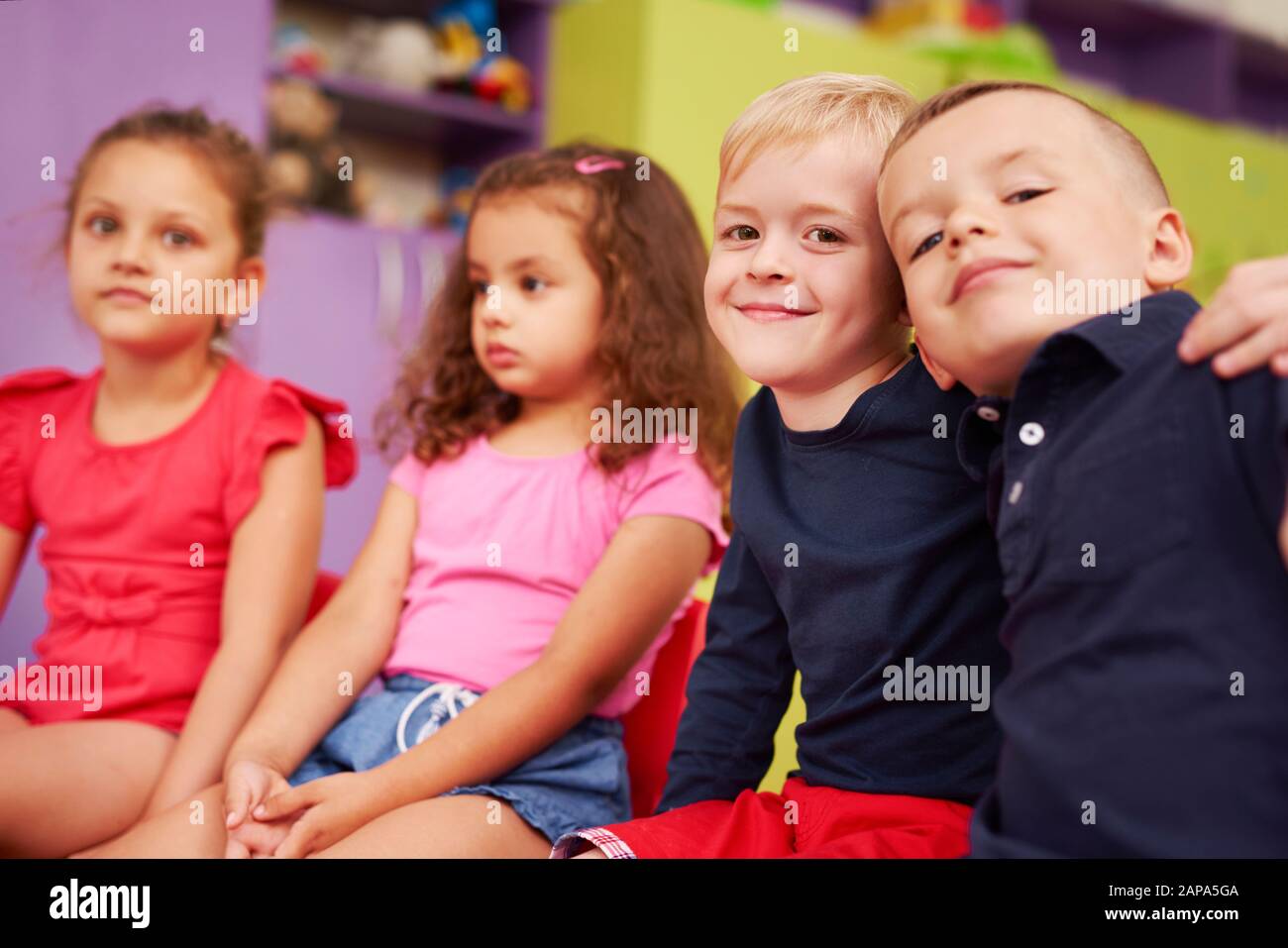 Portrait de deux garçons souriants embrassant dans la maternelle Banque D'Images