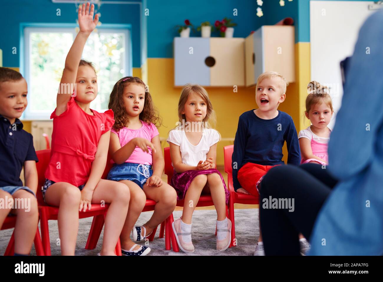 Fille levant la main pour poser une question en classe Banque D'Images