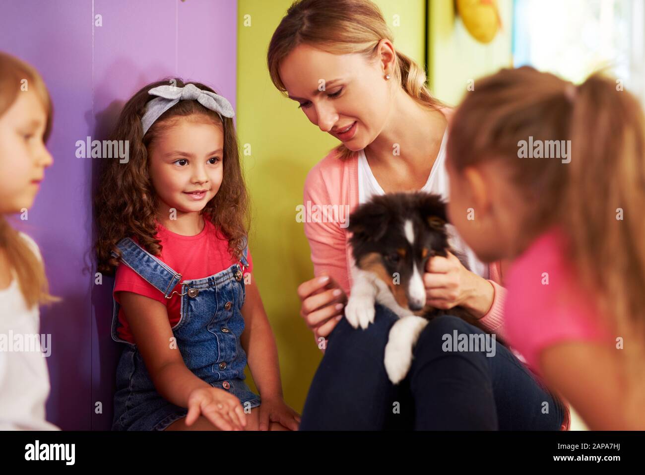 Professeur et enfants qui s'intéressent au chien dans la maternelle Banque D'Images
