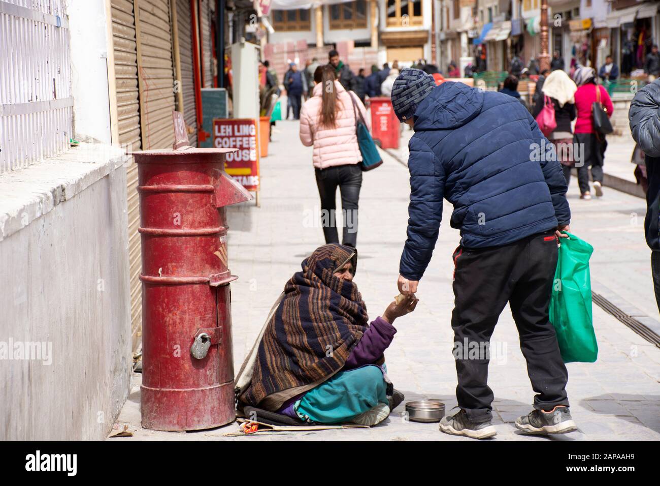 Jammu CACHEMIRE, INDE - 19 MARS : les Tibétains donnant de l'argent à la vieille femme indienne mendiant ou intouchables caste assis et mendiant sur le marché à Leh la Banque D'Images