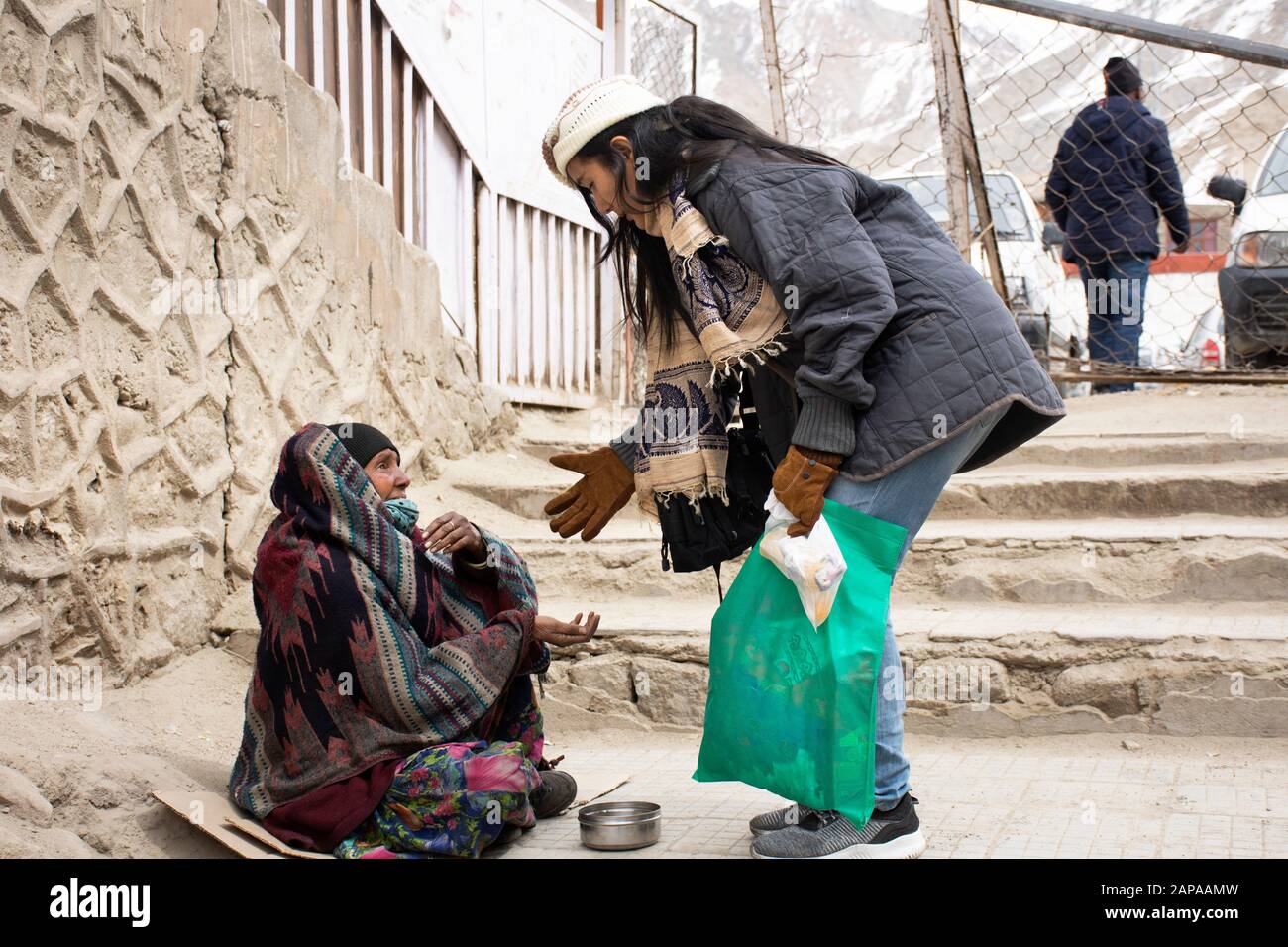 Jammu CACHEMIRE, INDE - 19 MARS : Les Voyageurs thaïlandais donnent de l'argent à la vieille femme indienne beggar ou intouchables caste assis et mendier sur le marché au le Banque D'Images