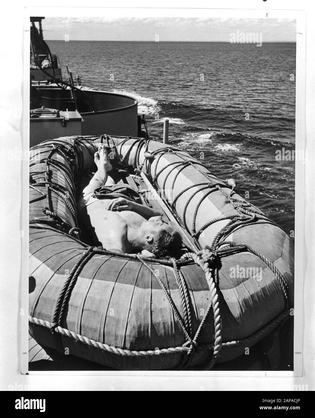 Marine [Marine] Anefo London Series Description: À bord d'un croiseur néerlandais dans le sud-ouest de l'océan Pacifique. Un membre de l'équipage bronzer dans un bateau de sauvetage. Annotation : Repronegative Date : 1940-1945 mots clés : Marine, officiers, navires de guerre, seconde Guerre mondiale Banque D'Images