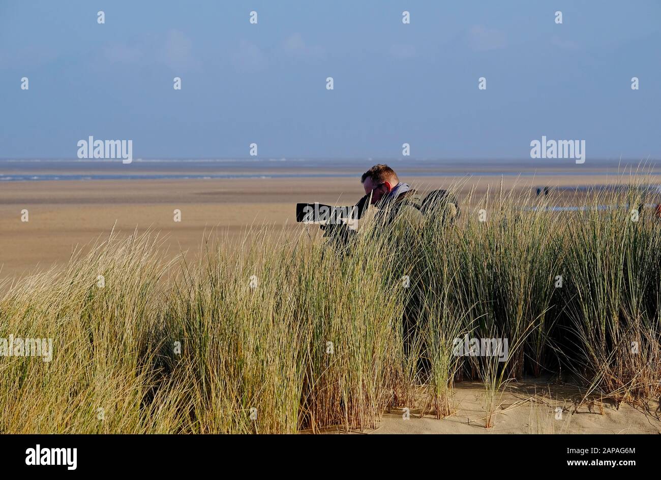 observateur d'oiseaux de sexe masculin utilisant la portée, holkham beach, nord norfolk, angleterre Banque D'Images