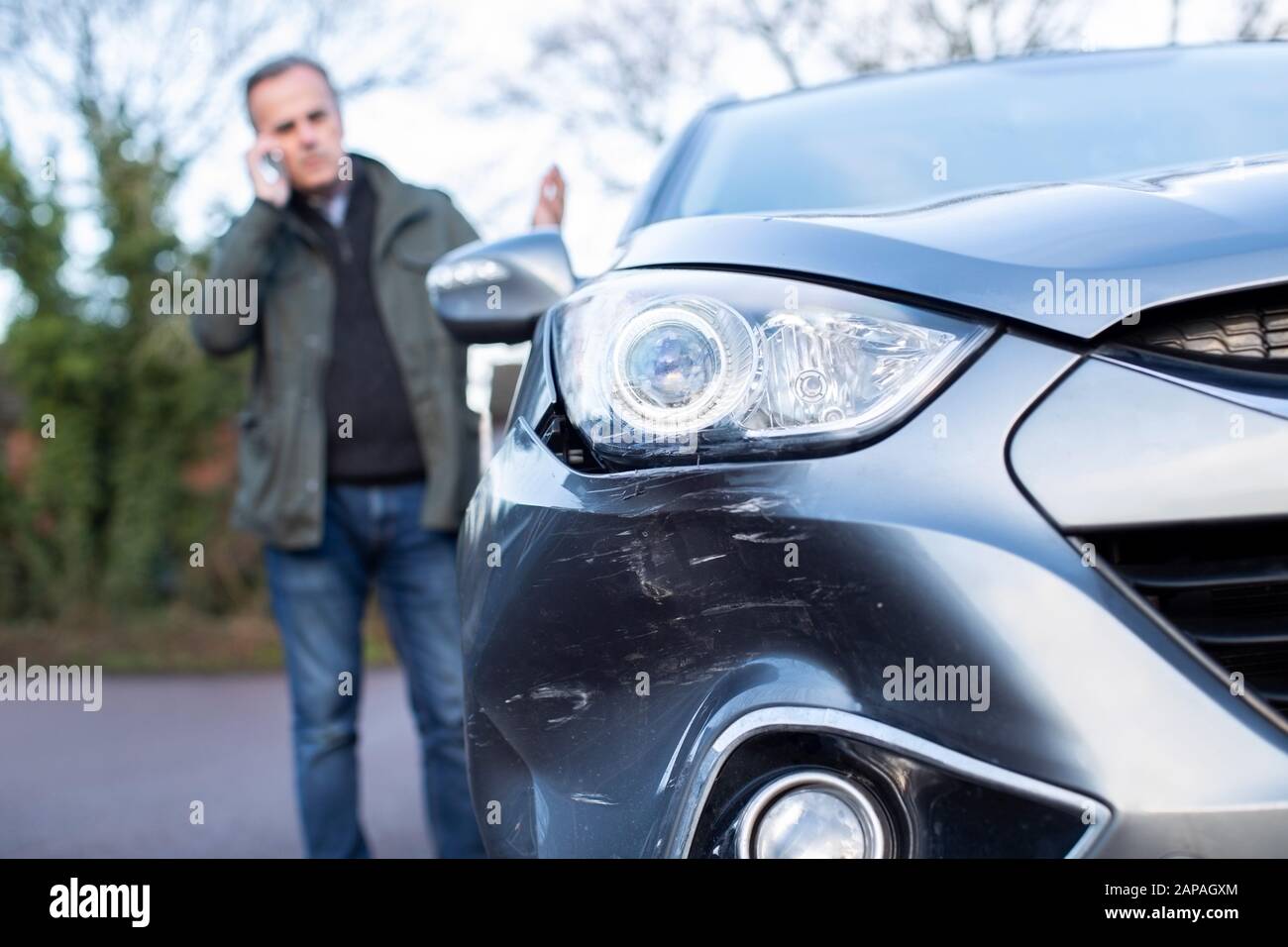 Un Homme D'Âge Mûr Mécontent Avec Une Voiture Endommagée Après Un Accident En Appelant La Compagnie D'Assurance Sur Le Téléphone Portable Banque D'Images