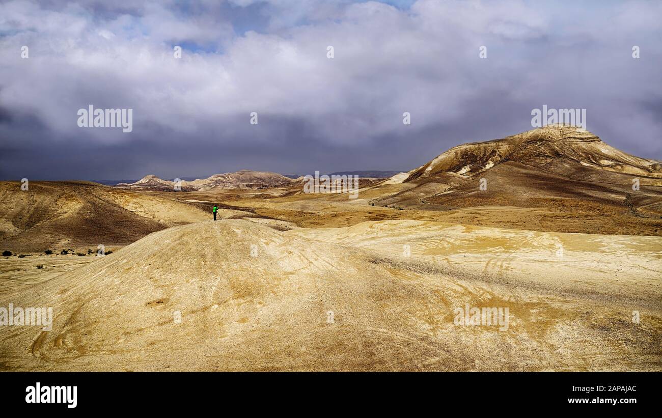 Tempête de nuages et une petite figurine d'un photographe sur une colline dans le désert. Banque D'Images