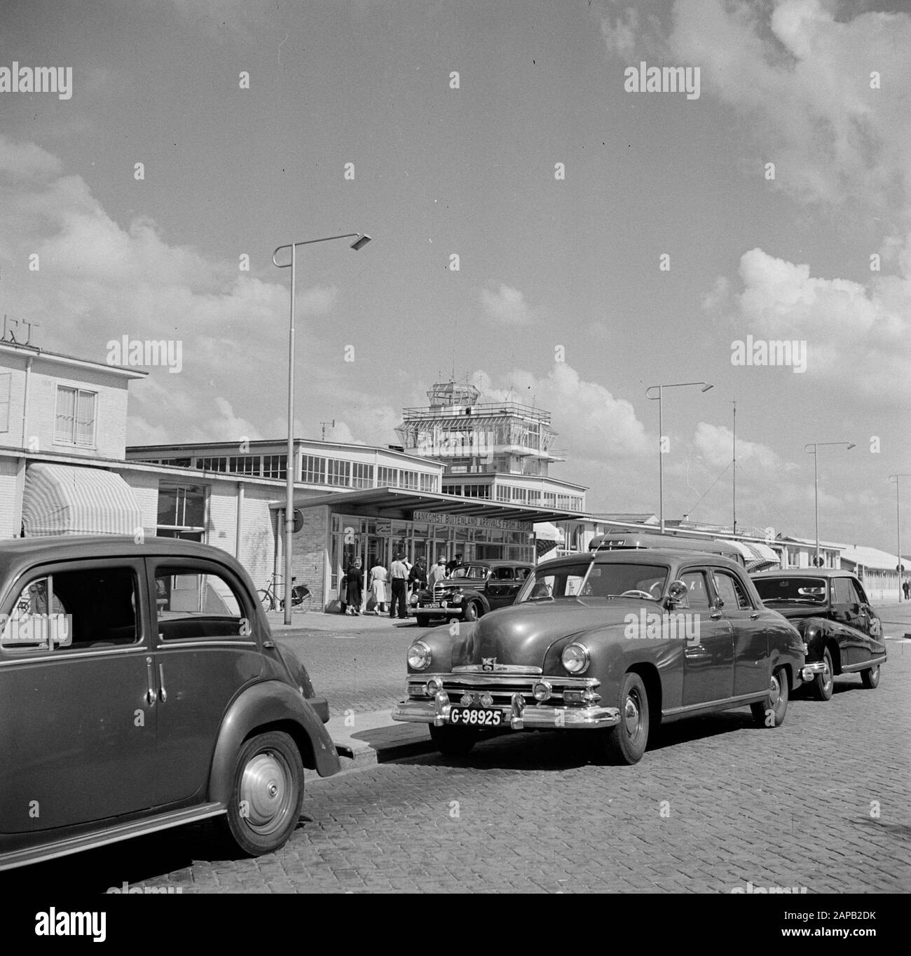 Schiphol et identité corporative KLM Description: Aéroport de Schiphol avec entrée principale et hall de départ, en arrière-plan la tour de contrôle de la circulation Date: Août 1951 lieu: Noord-Holland, Oud-Schiphol mots clés: Salles d'arrivée et de départ, voitures, voitures, tours de circulation, aéroports Banque D'Images