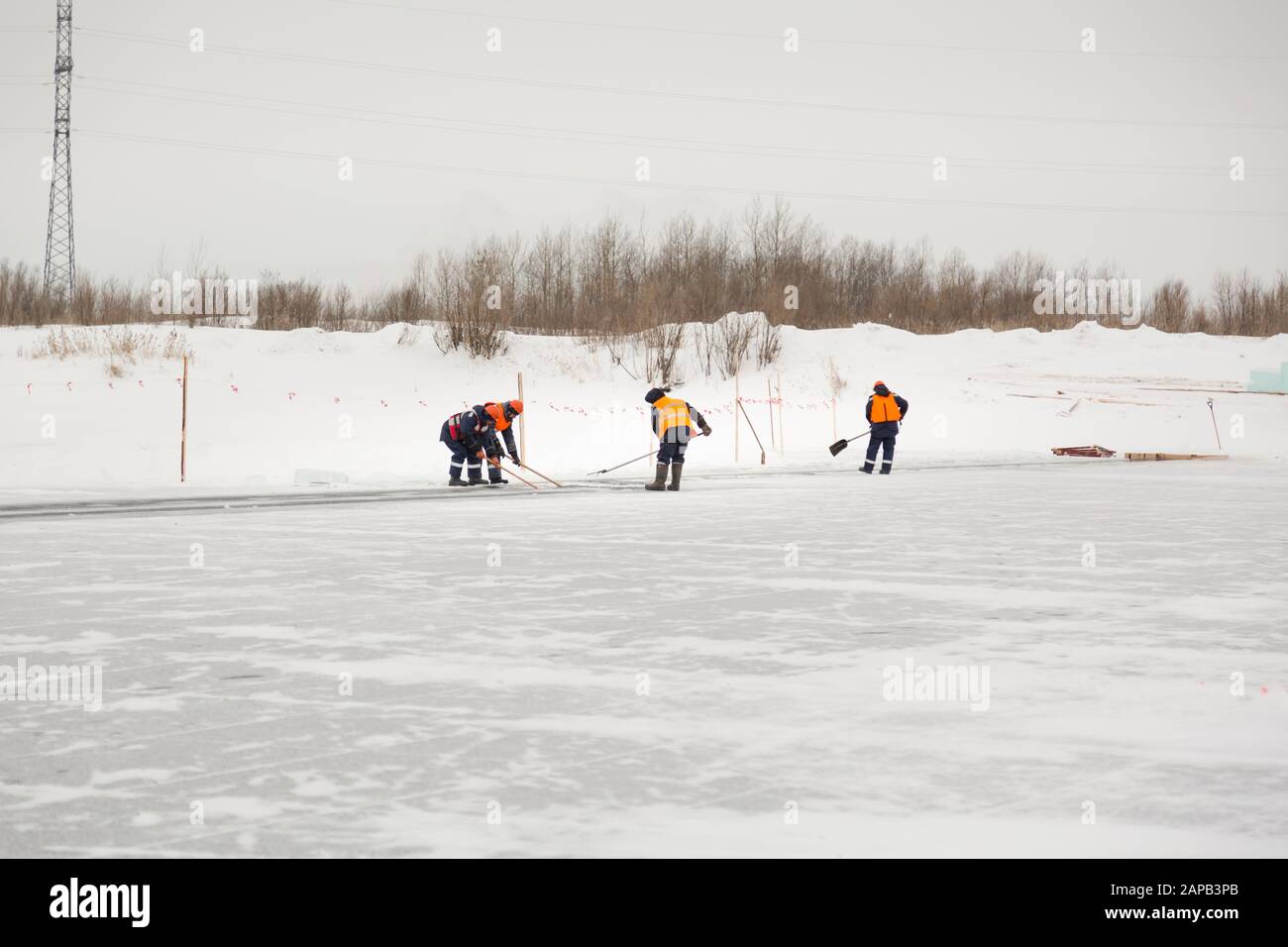 Les employés radeau des blocs de glace le long d'une chaîne coupée un lac gelé Banque D'Images