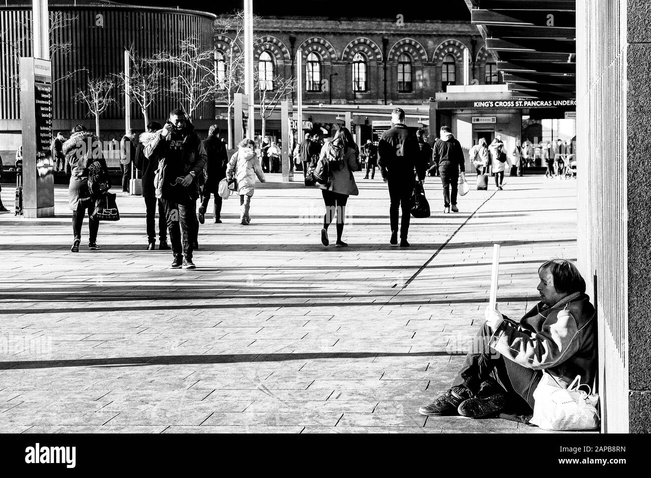 Londres 21 décembre 2020: L'homme sans abri s'endormit avec ses biens personnels un jeune homme affiche un signe demandant de l'aide, malgré une rénovation de plusieurs millions de livres, Kings Cross Square, la gare souterraine est encore une attraction pour les sans-abri, avec l'itinérance en hausse, Les stations ont leur propre politique quant à la façon et quand on demande aux traverses agitée de partir, avec plus de 16000 personnes dormant des nuits difficiles à Londres. Le gouvernement fournit des fonds pour maintenir un certain nombre de refuges pour sans-abri en service. Les mois d'hiver sont les pires pour les traverses rugueuses avec des conditions de gel. :Clifford Norto Banque D'Images