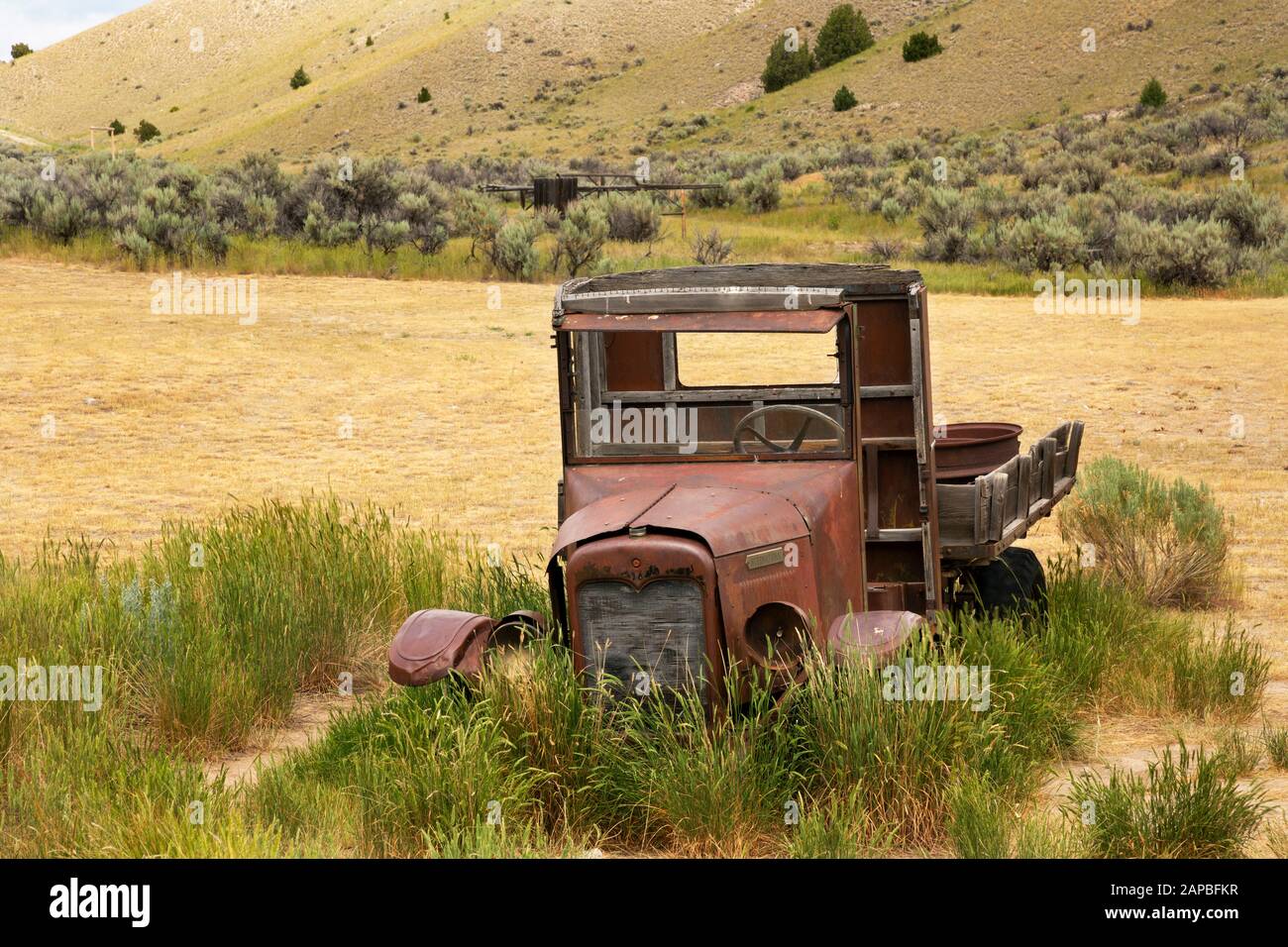 MT00422-00...MONTANA - ancien camion avec une roue en bois abandonnée dans un champ à côté de la ville fantôme de Bannack au parc national de Bannack. Banque D'Images