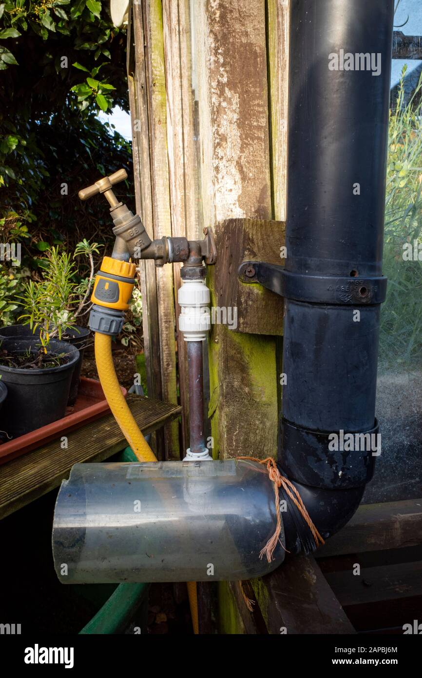 Tuyau en duvet avec une partie d'une bouteille en plastique montée pour  filtrer l'eau de pluie dans l'eau, mais Photo Stock - Alamy