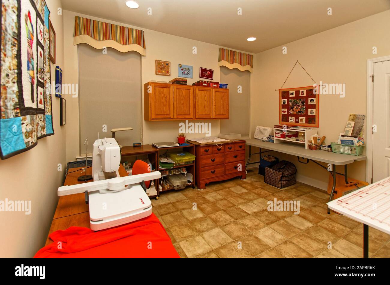 Salle à coudre, maison, 2 fenêtres, abat-jour, décorations murales en fibre d'art, armoires, table de découpe, machine à coudre, table de travail, fournitures, horizontal; PR Banque D'Images