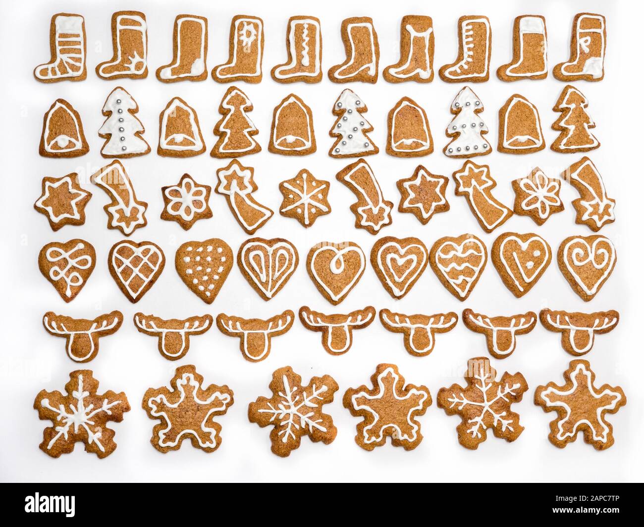 Assortiment de biscuits au pain d'épices dans des formes liées à Noël avec givrage blanc tiré d'en haut sur blanc Banque D'Images