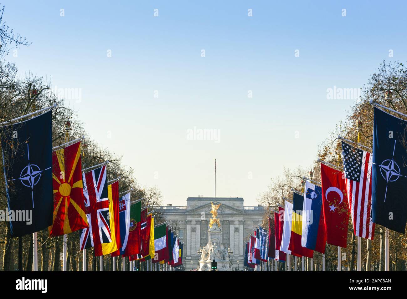 Buckingham Palace, résidence officielle du monarque britannique avec les drapeaux des nations de l'OTAN bordant le Mall, la rue devant le palais Banque D'Images