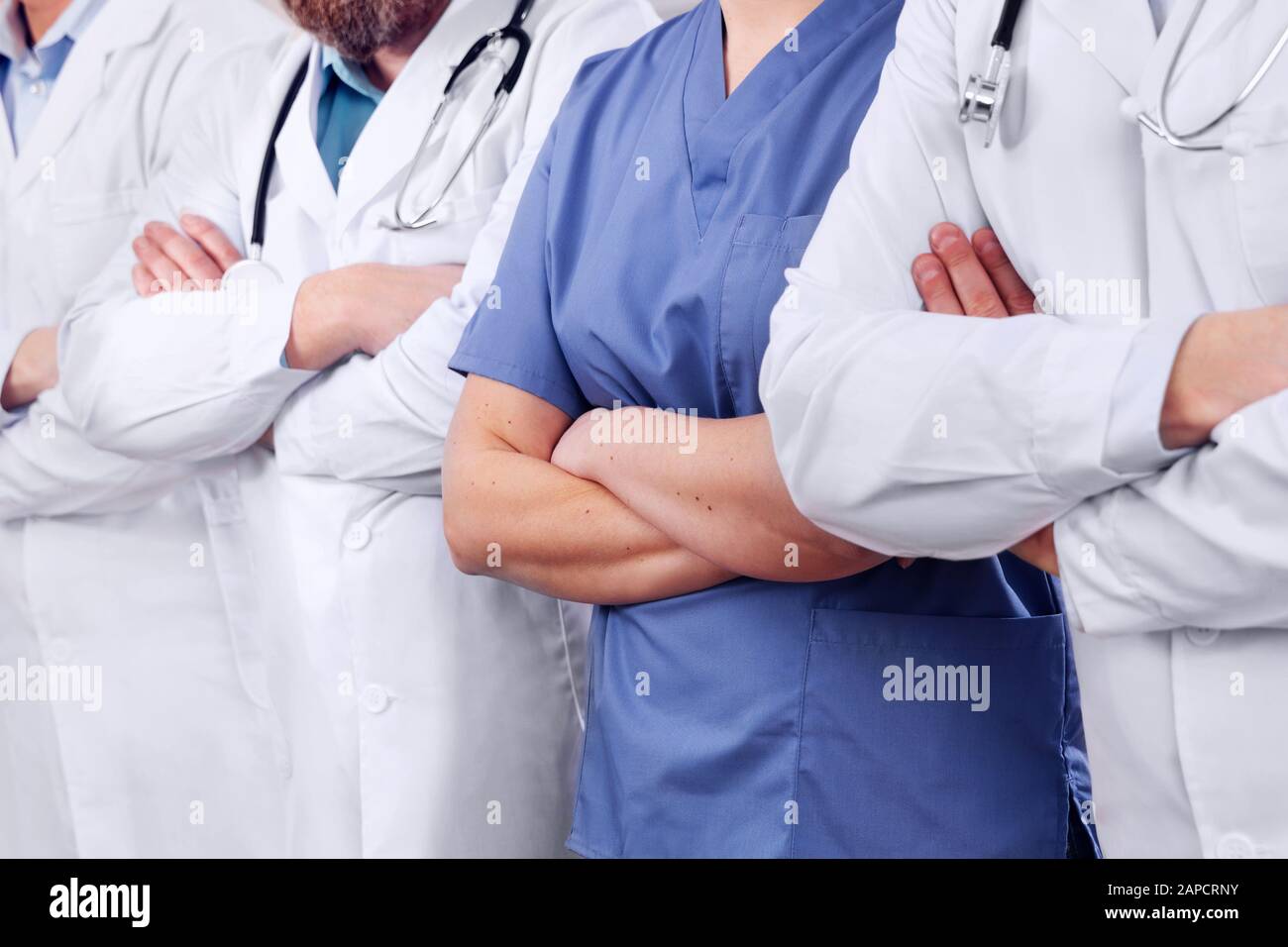 Médecins et chirurgiens de l'équipe de soins de santé avec des bras croisés dans une rangée à l'hôpital Banque D'Images
