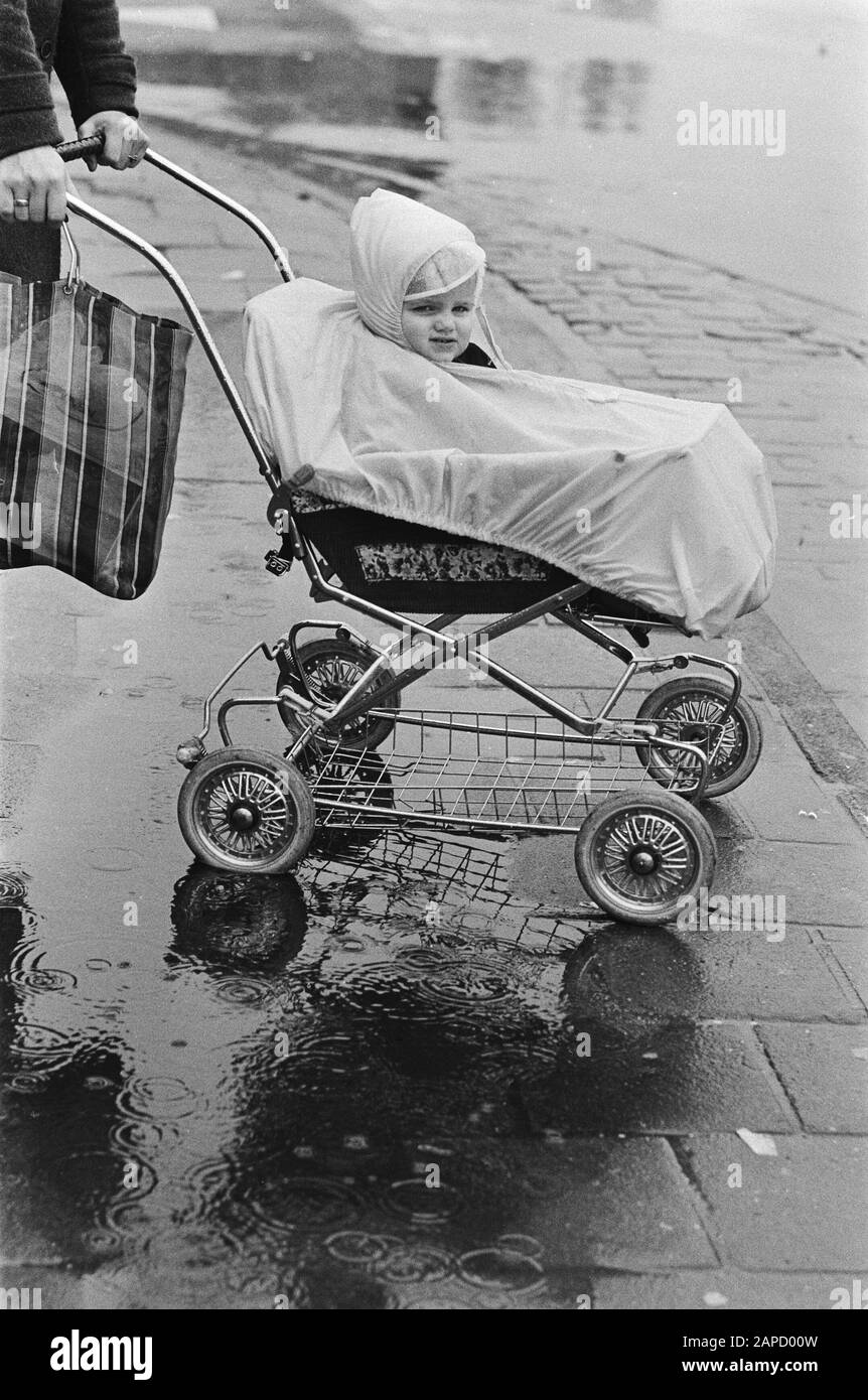 Ces derniers jours, il a presque été détruit par un enfant dans une poussette avec un pont de pluie Date: 10 mars 1981 mots clés: Enfants, pluie Banque D'Images