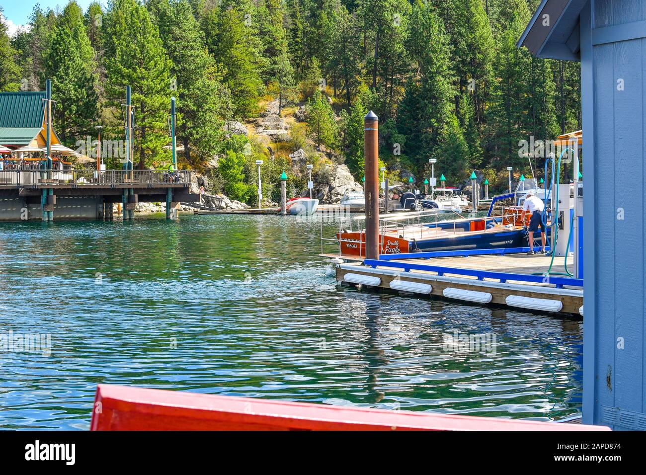 Un homme met de l'essence dans le réservoir de son hors-bord à une marina de lac de montagne dans le nord de l'Idaho, aux États-Unis Banque D'Images