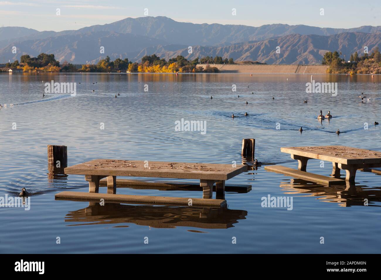 Un lac de Cafilornia qui est submergé en raison de fortes chutes de pluie avec de l'eau enfermant les bancs du parc. Banque D'Images