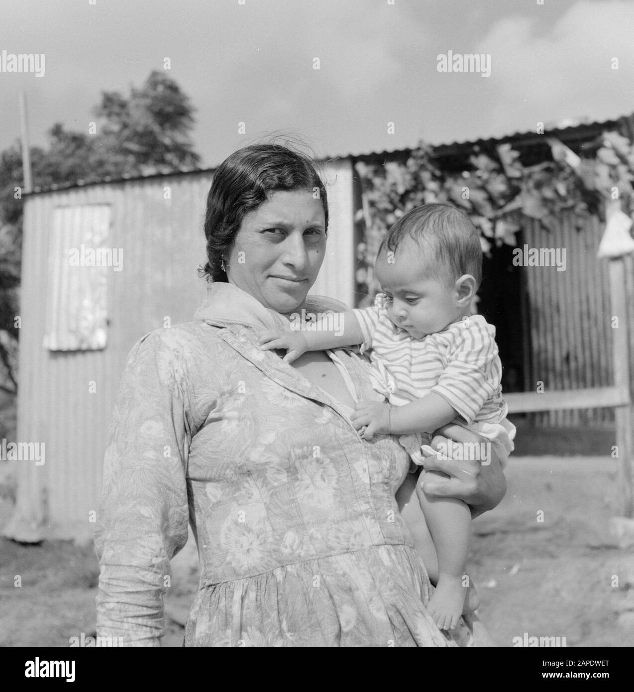 Femme arabe avec bébé. A l'arrière-plan un petit bâtiment de feuilles ondulées Date: 1 janvier 1964 lieu: Israël mots clés: Bébés, feuilles ondulées, enfants, portraits Banque D'Images Femme arabe avec bébé. A l'arrière-plan un petit bâtiment de feuilles ondulées Date: 1 janvier 1964 lieu: Israël mots clés: Bébés, feuilles ondulées, enfants, portraits Banque D'Images