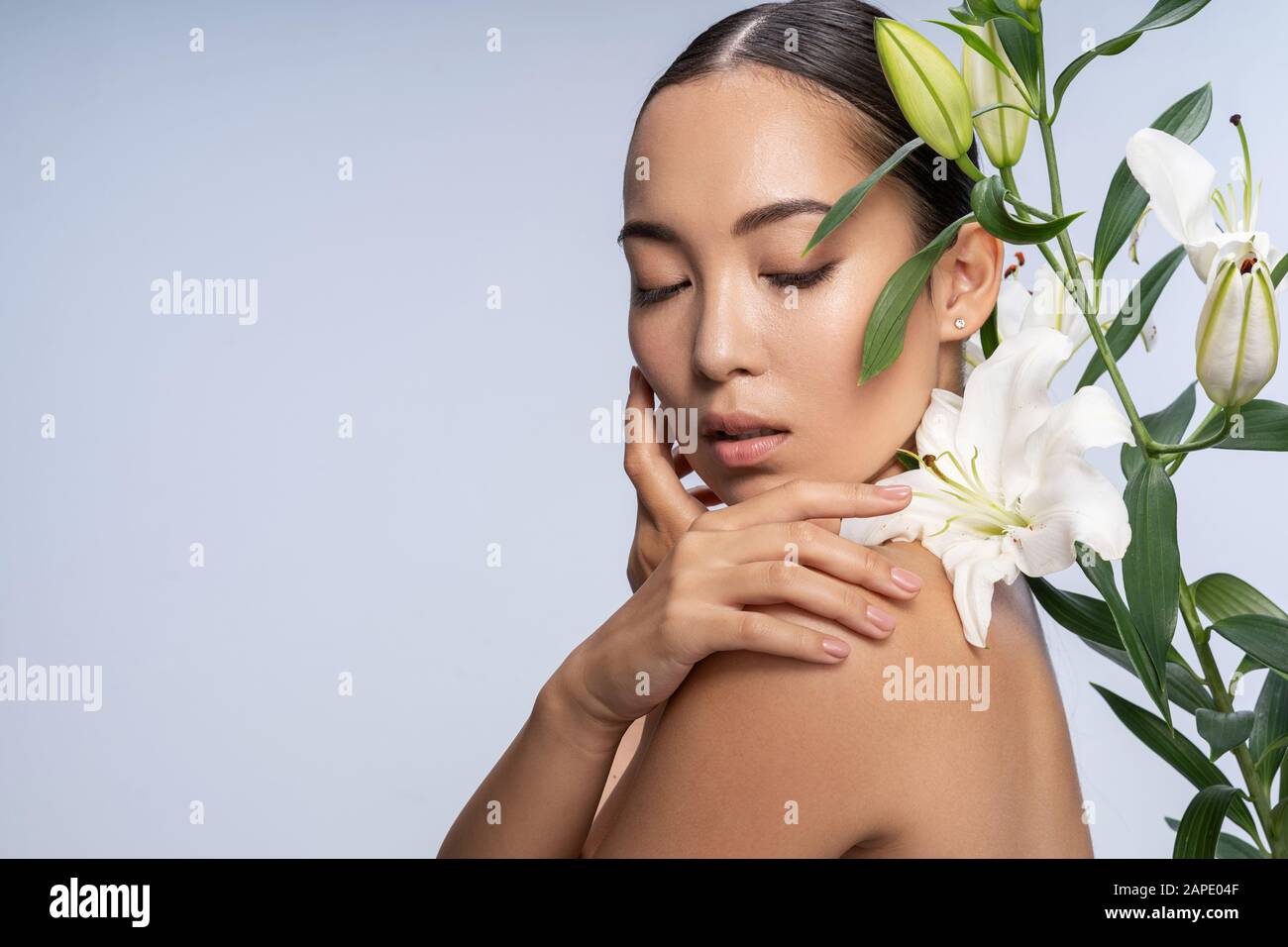 Une dame asiatique tendre posant avec un beau bouquet en studio Banque D'Images