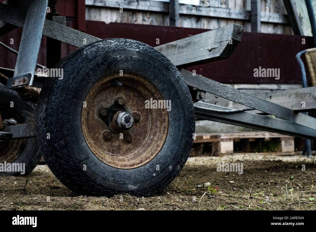 Roue d'un tracteur stationné dans une ferme avec un arrière-plan flou Banque D'Images