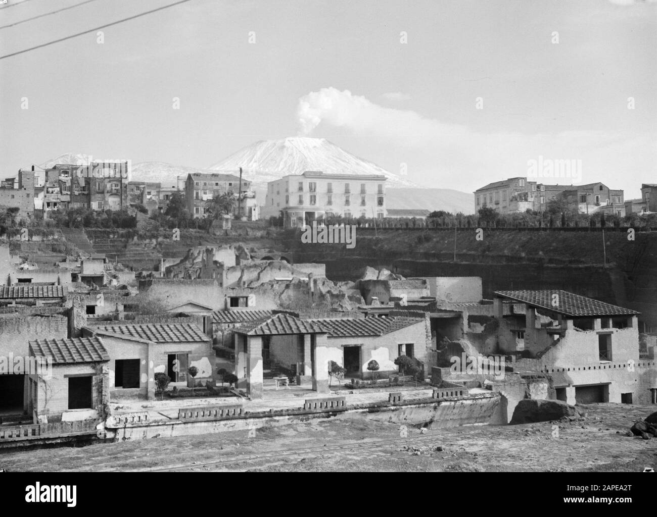 Italie Description: Image des ruines de la ville d'Herculaneum avec en arrière-plan le Vésuve Date: Non daté mots clés: Archéologie, fouilles, ruines, volcans, maisons Banque D'Images