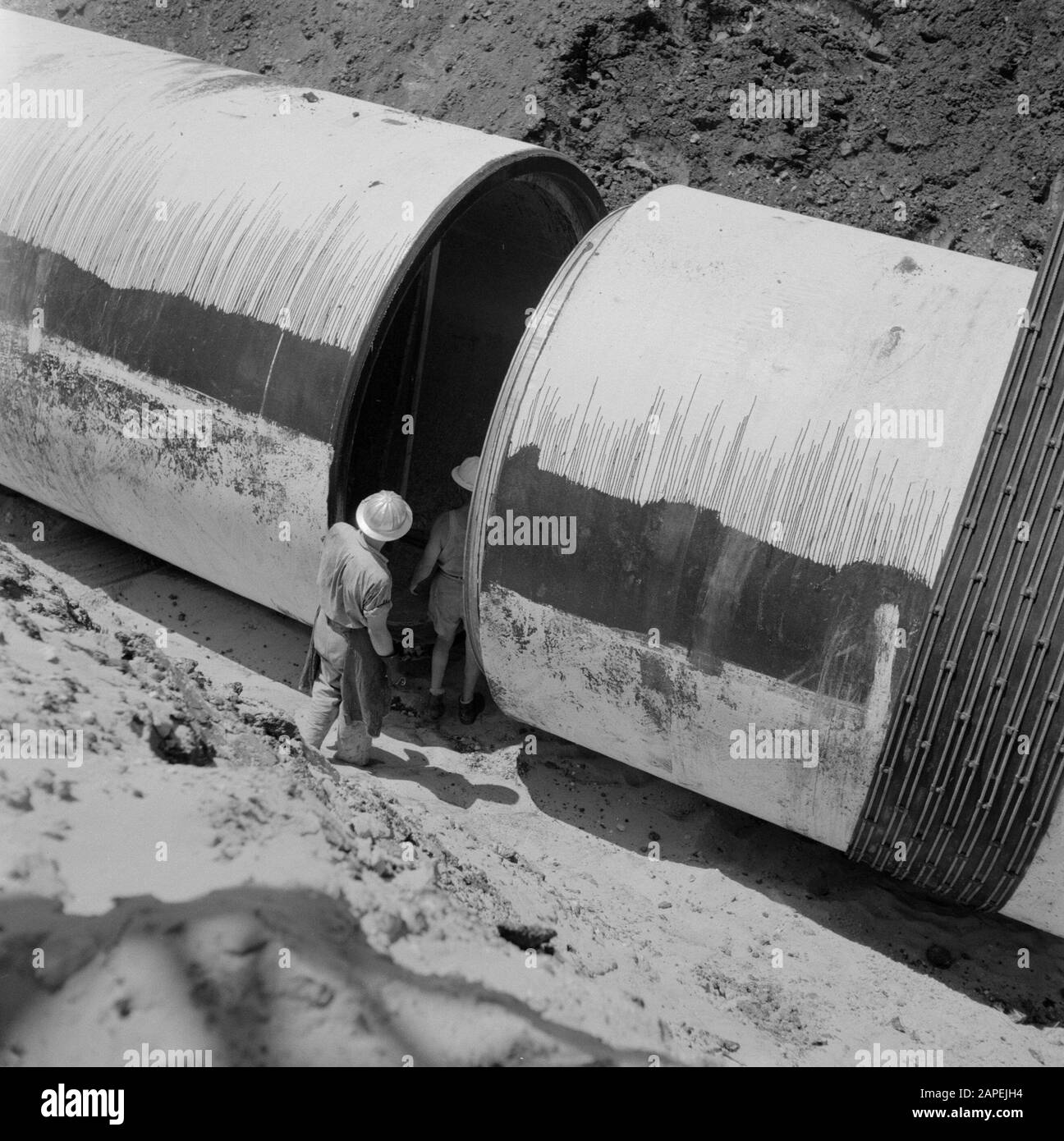 Projet d'irrigation dans le désert du Negev. Les tubes sont posés dans un fossé avec une dragline Date: 1 janvier 1960 lieu: Israël, Negev mots clés: Travailleurs, travaux d'irrigation, tubes, grues, pipelines Banque D'Images