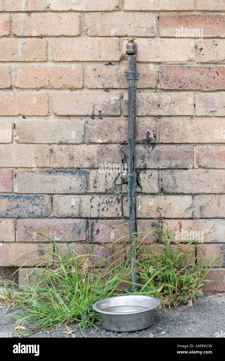 Un tuyau en cuivre et un robinet extérieur monté contre un mur de briques  avec de la peinture éclabouillée sur le mur Photo Stock - Alamy