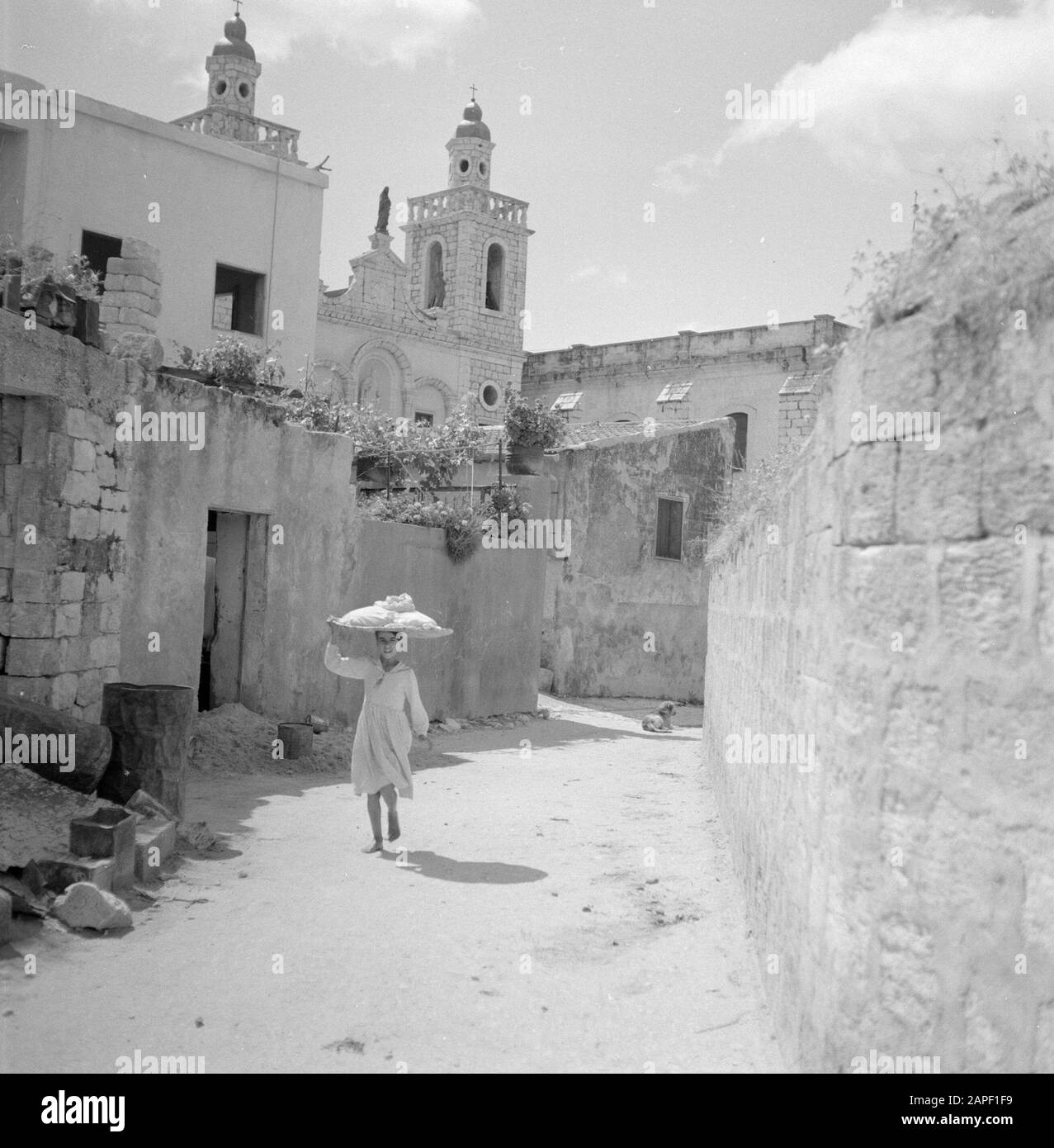 Israël: Kana Description: Marcher pieds nus fille dans une rue avec une soucoupe sur la tête; en arrière-plan l'Église de mariage Annotation: Le terme Église de mariage se réfère au miracle Jésus de Nazareth , changer l'eau dans le vin pendant le mariage de Kana Date: Non dédrée lieu: Galilée, Israël, Cana mots clés: bâtiments d'église, filles, images de rue Banque D'Images