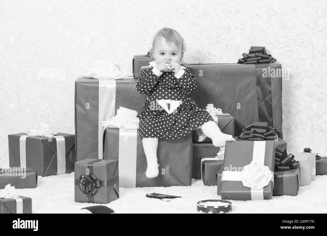 Little baby girl jouer près de tas de boîtes cadeaux. Vacances en famille. Des cadeaux de Noël pour tout-petit. Cadeaux pour enfant premier noël. Première fête de Noël. Premier Noël de bébé, au cours de la vie, une fois l'événement. Banque D'Images