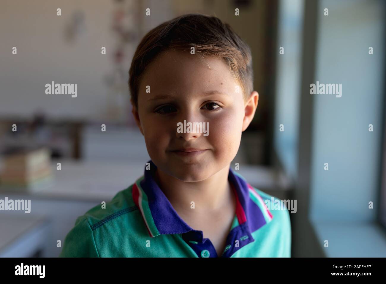 Un écolier qui cherche un appareil photo dans une salle de classe de l'école primaire Banque D'Images