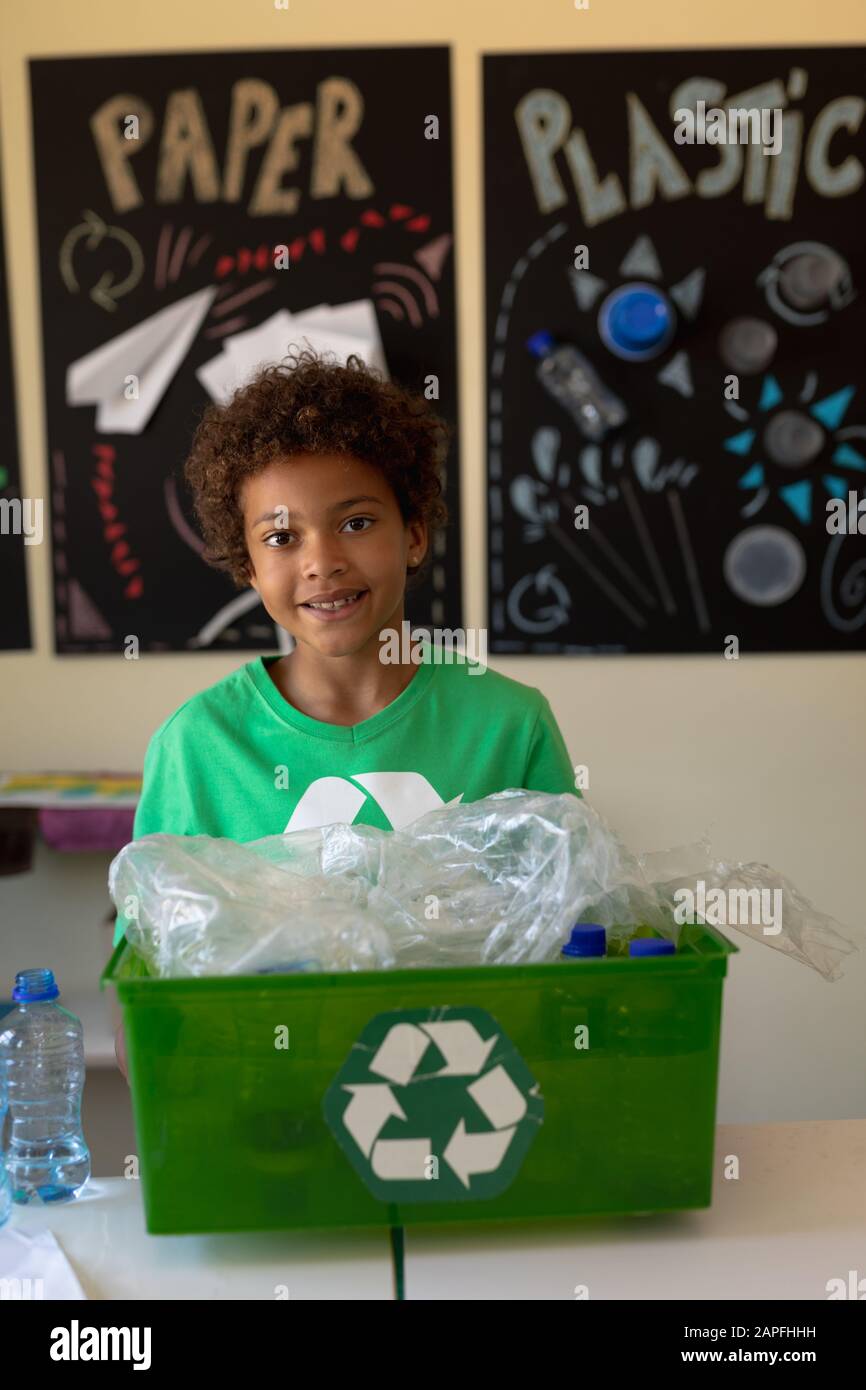 L'écolier porte un t-shirt vert avec un logo de recyclage blanc Banque D'Images