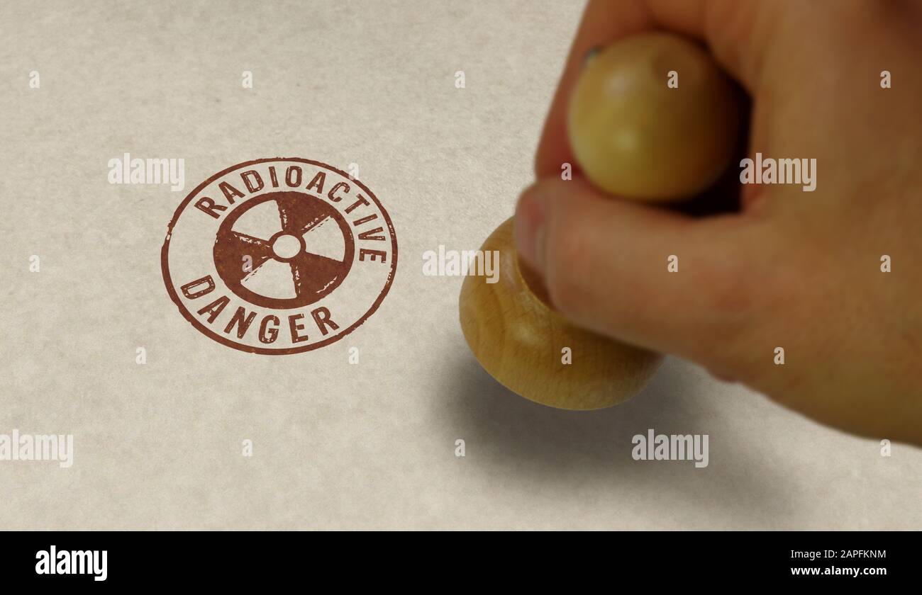 Symbole de danger radioactif estampille et main de marquage. Concept d'avertissement d'énergie atomique, d'alerte aux radiations et de risque d'énergie nucléaire. Banque D'Images