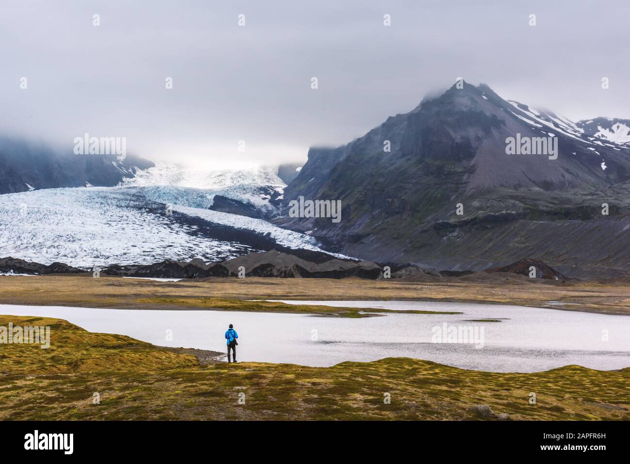 Un touriste solitaire près de la lagune glaciaire de Vatnajokull. Parc National De Vatnajokull, Sud-Est De L'Islande, Europe. Photographie de paysage Banque D'Images