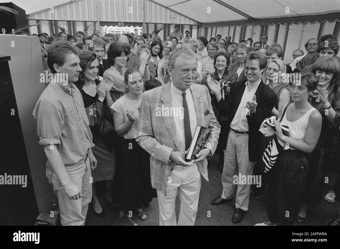 Cabarethistorian Jacques Klöters a écrit 100 ans de divertissement aux Pays-Bas. L'auteur a remis à Toon Hermans le premier exemplaire. Sur la photo Hermans après la cérémonie de remise des prix à carré à Amsterdam. [Tout à gauche Michiel Buchel, troisième à partir de gauche Jean-Pierre Rawie, à droite à côté de Toon Hermans Conny Stuart, applaudissant Kick van der Veer, à droite Jos van Doesburg. J.Klöters n'est pas visible sur la photo.] Date: 1 juillet 1987 lieu: Amsterdam, Noord-Holland mots clés: Artistes, livres, cabaret Nom personnel: Buchel, Michiel, Doesburg, Jos van, Hermans, Toon, Rawie, Jean-Pierre, Stuart, Conny, Veer, Kick v Banque D'Images