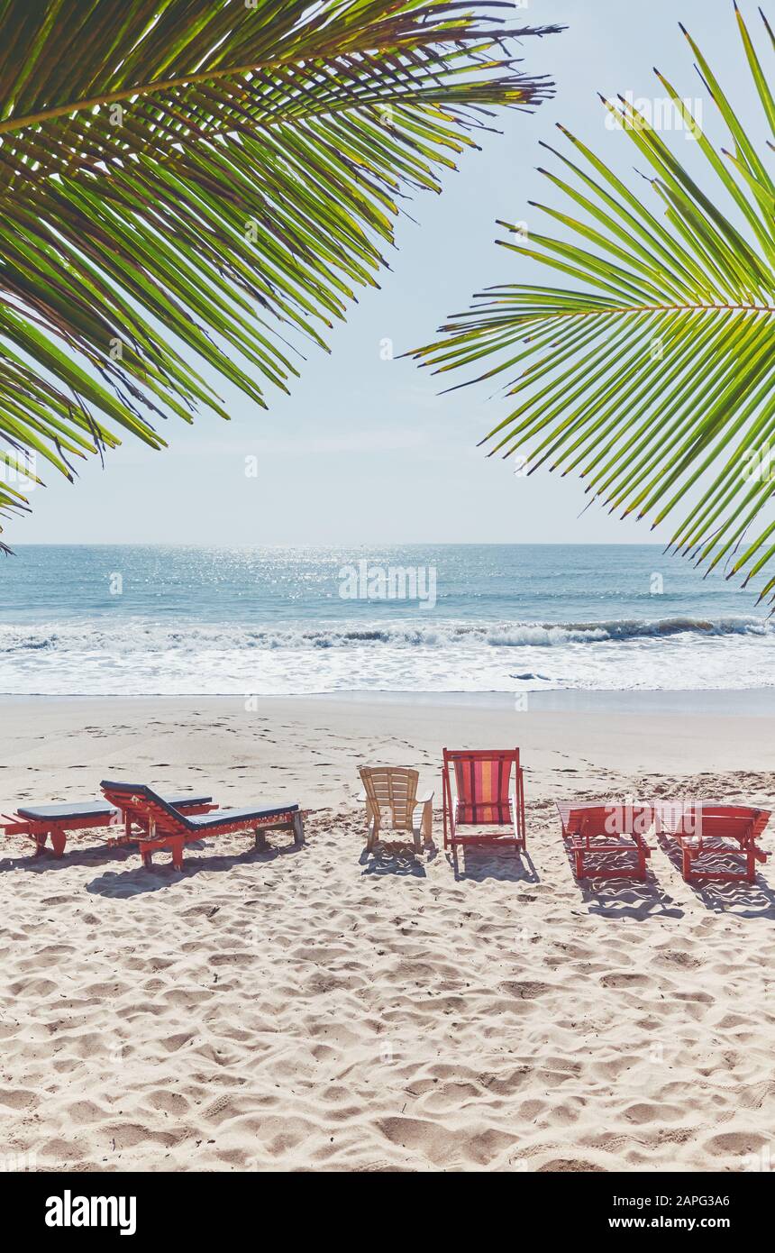 Chaises longues vides sur une plage tropicale, concept de vacances d'été, coloration appliquée. Banque D'Images