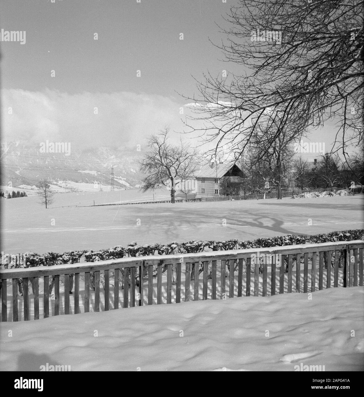 Hiver au Tyrol Description: Chalet maison dans la neige avec des nuages enveloppés dans le fond des montagnes Karwendel Date: Janvier 1960 lieu: Autriche, Sistrans, Tyrol mots clés: Montagnes, paysages, neige, hiver, nuages, maisons Banque D'Images