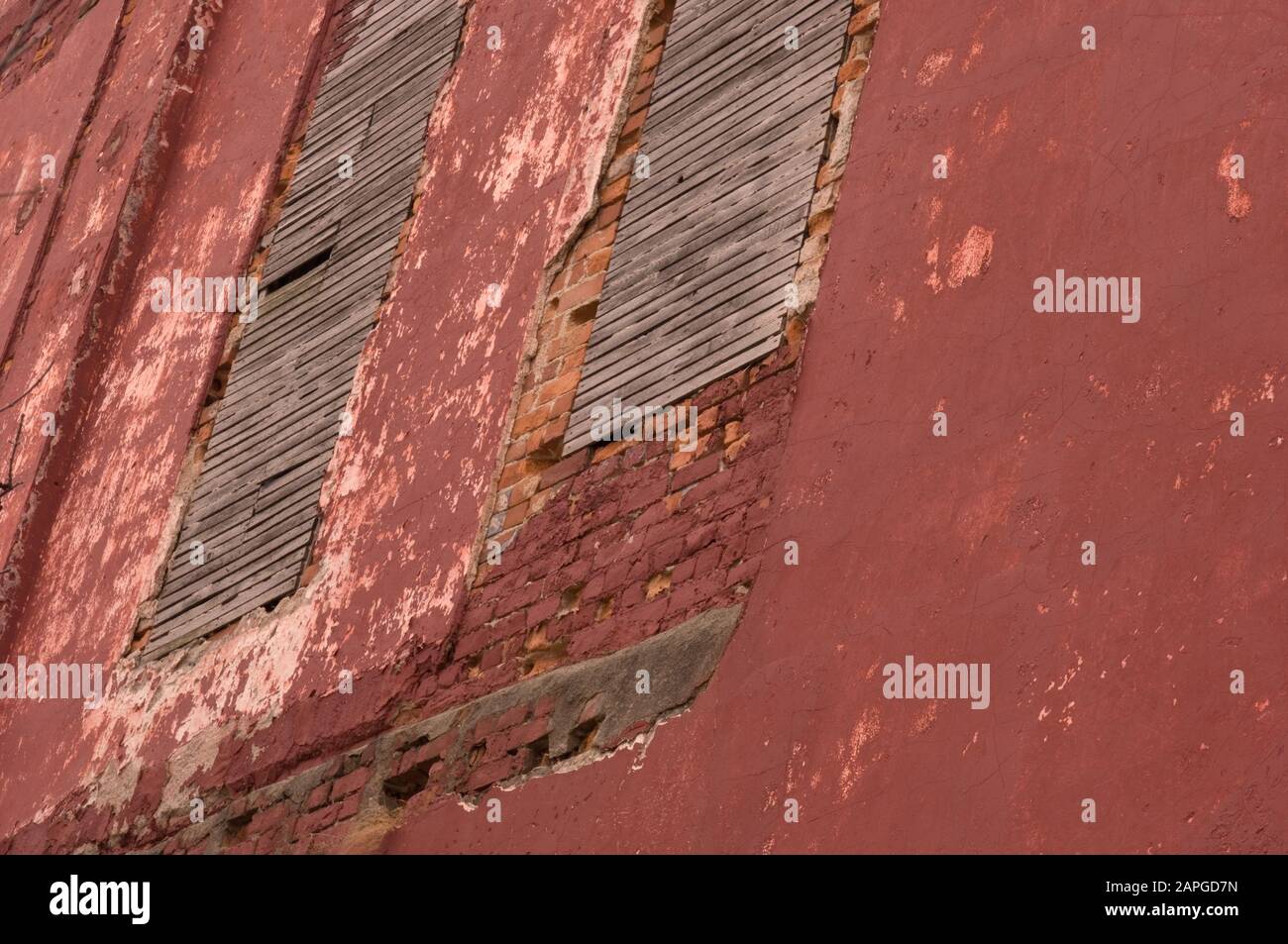 Vieux mur rouge sale avec des briques peintes sous la lumière du soleil - une image fraîche pour un arrière-plan Banque D'Images