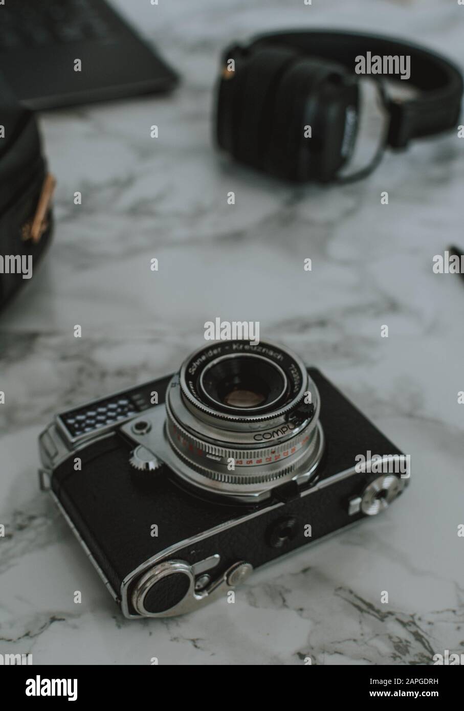 Prise de vue verticale d'un appareil photo, d'un casque et d'un ordinateur portable placés sur une table en marbre Banque D'Images