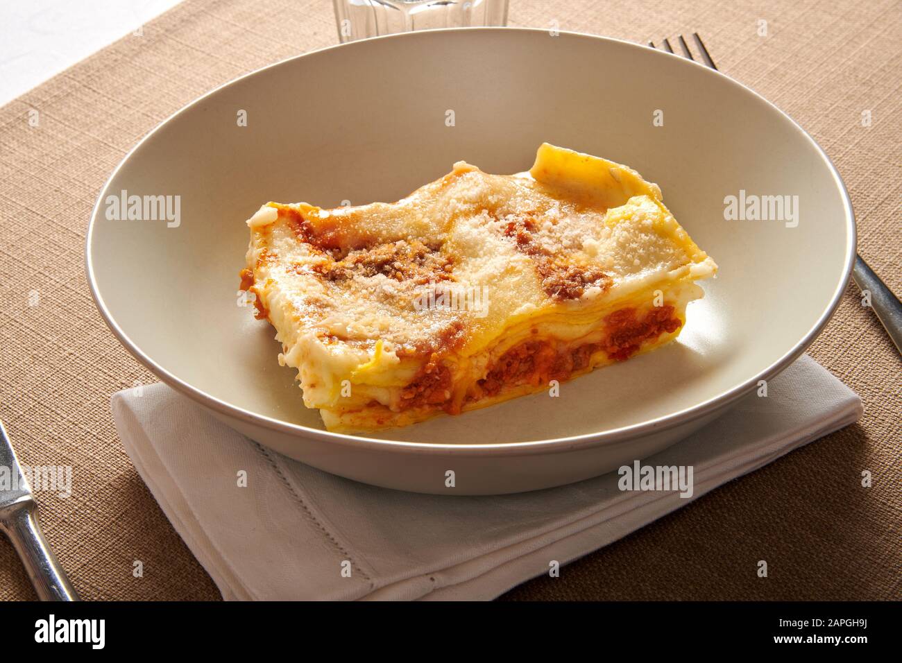 Portion de Lasagna alla Bolognese un plat de pâtes régionales de la région de l'Emilie Romagne d'Italie servi dans un bol à table dans une vie à grand angle Banque D'Images