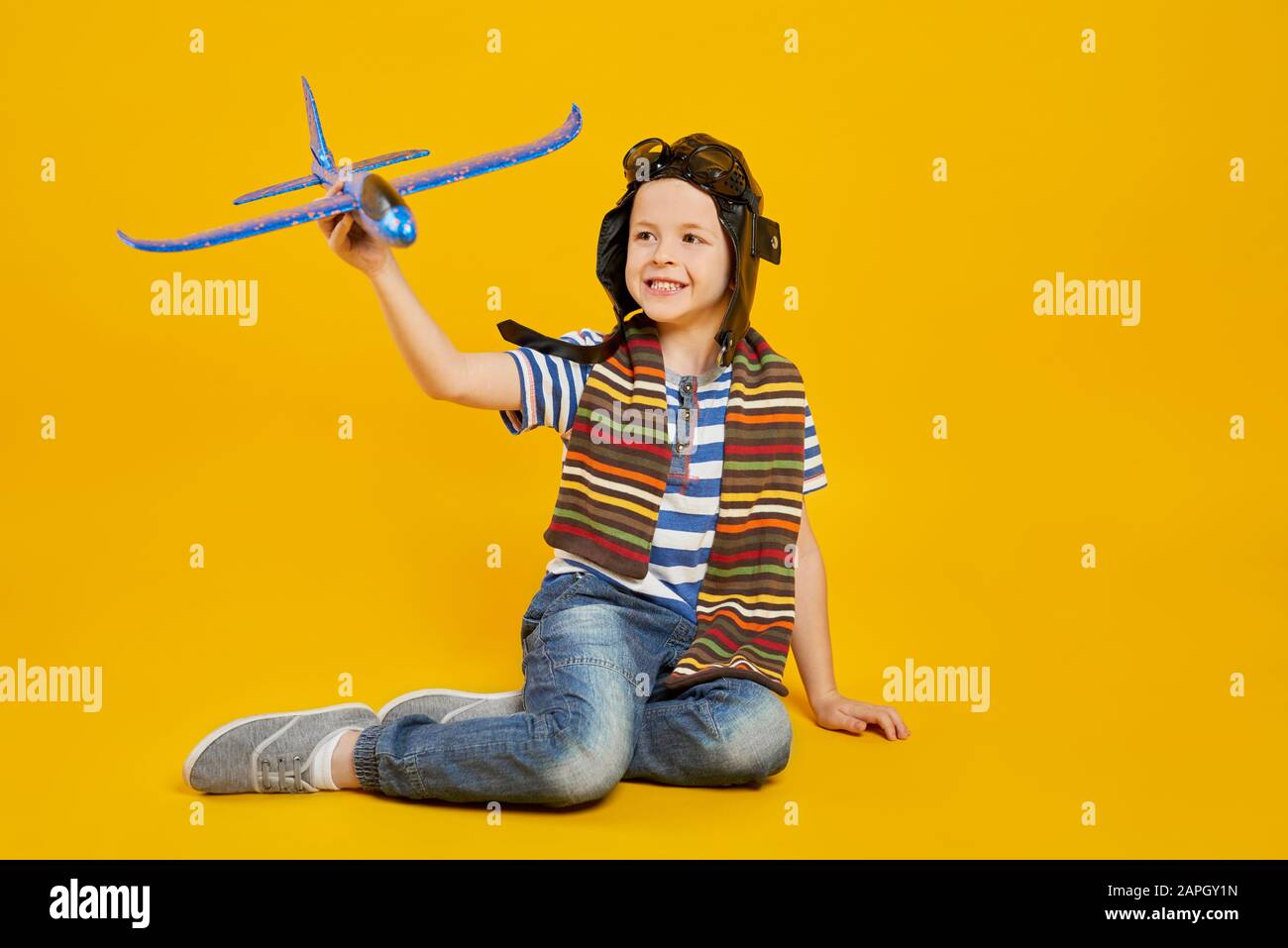 Un garçon souriant jouant avec un avion jouet Banque D'Images