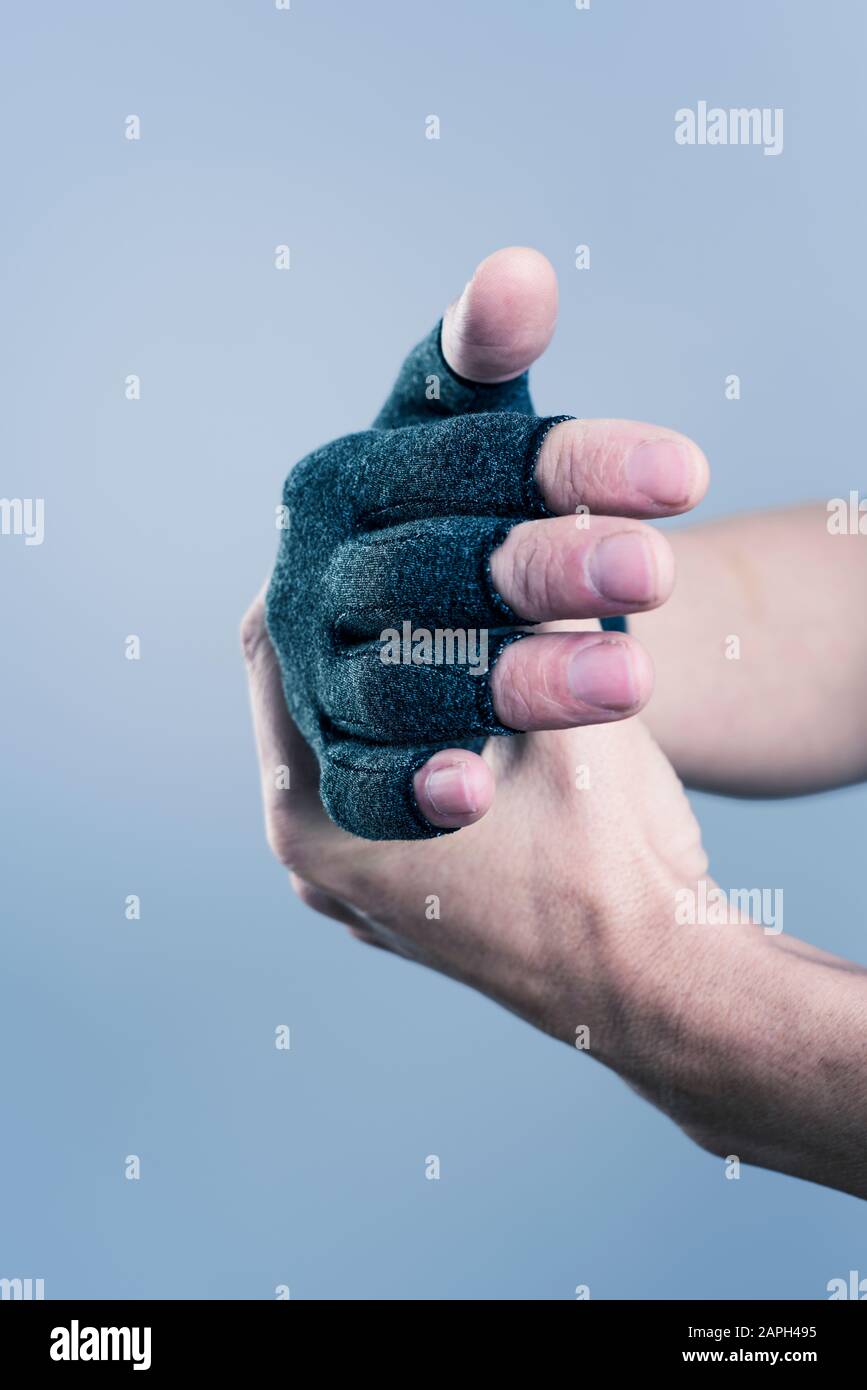 gros plan d'un homme caucasien portant un gant de compression gris foncé Banque D'Images