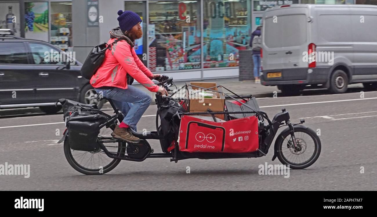 Vue latérale d'une nouvelle idée d'affaires pilotée par l'application Pedal Me à l'aide d'un vélo cargo et d'un chauffeur masculin pour effectuer un voyage de livraison de colis dans le centre de Londres Angleterre Royaume-Uni Banque D'Images