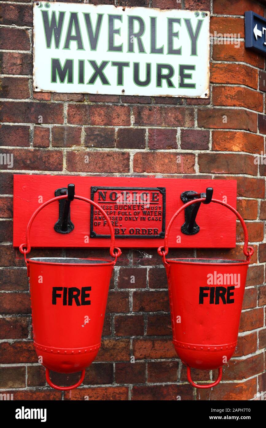 Seaux à feu et publicité en faveur du tabac À Mélange Waverley à l'ancienne sur le mur du bâtiment de la gare, la gare de la ville de Tenterden, le chemin de fer Kent & East Sussex, Kent, Angl Banque D'Images