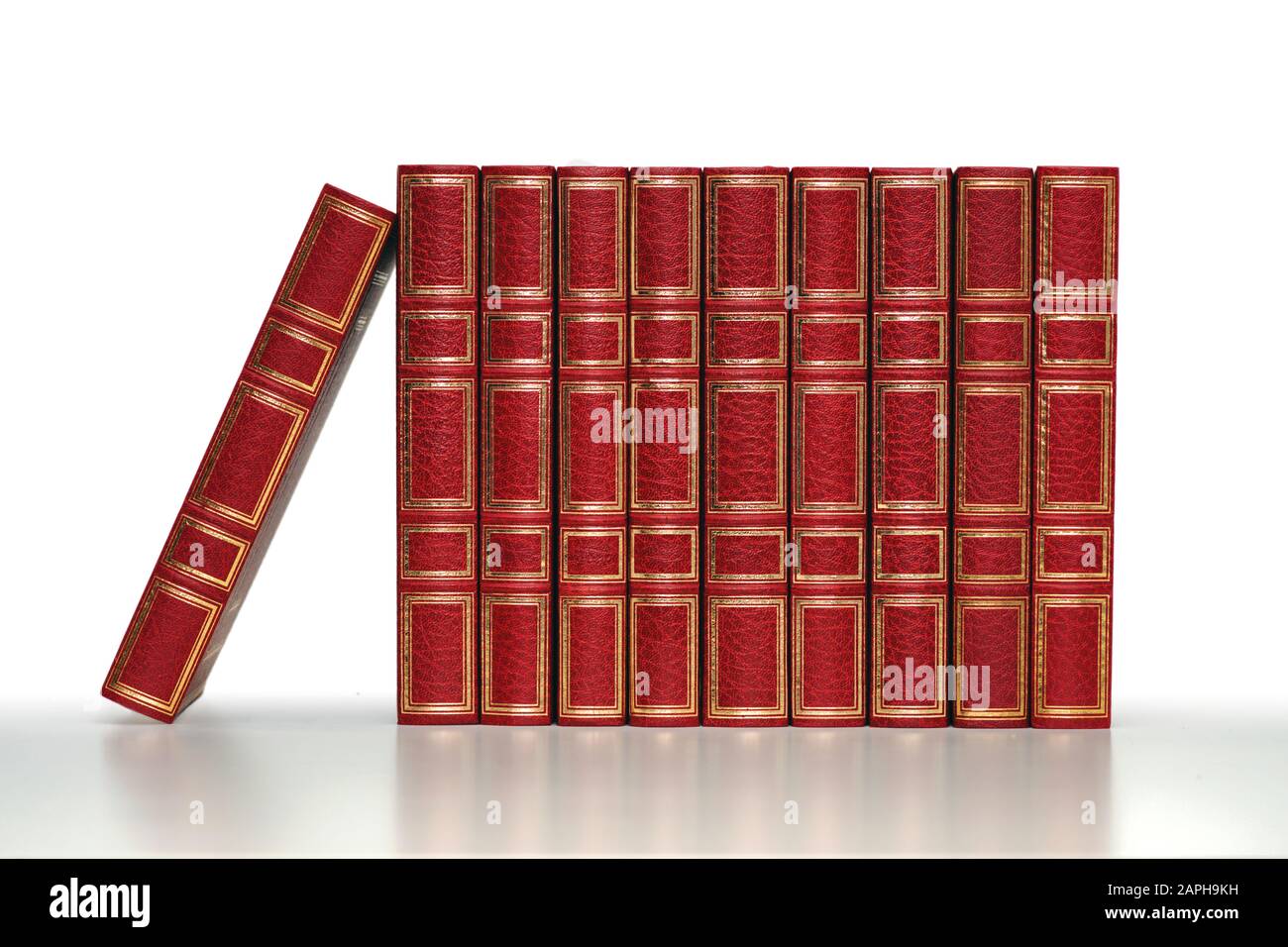 classiques rouge fermé livres dans une rangée sur fond blanc et gris pâle Banque D'Images