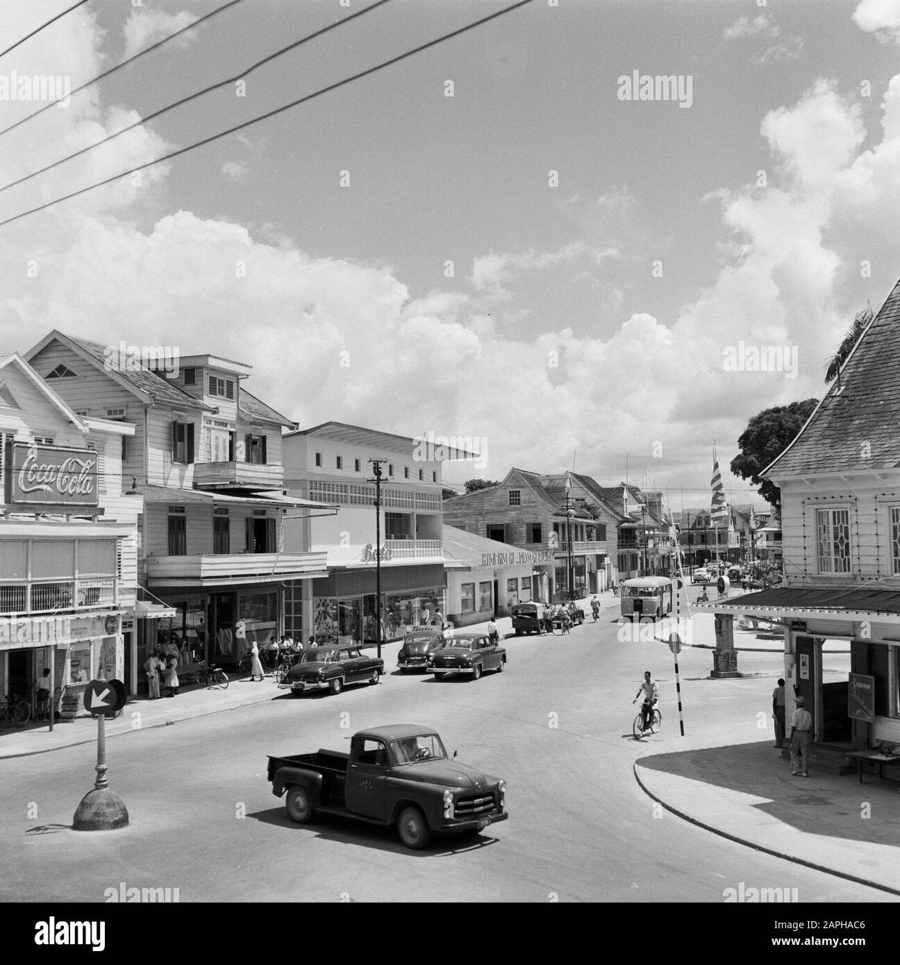 Antilles néerlandaises et Suriname au moment de la visite royale de la Reine Juliana et du Prince Bernhard en 1955 Description: Domineestraat dans le district d'Spanhoek à Paramaribo avec un magasin de chaussures Bata. Left a Coca-Cola Billboard Date: 1 octobre 1955 lieu: Paramaribo, Suriname mots clés: Voitures, publicité, images de rue, boutiques Nom personnel: Bata, spanhoek Banque D'Images