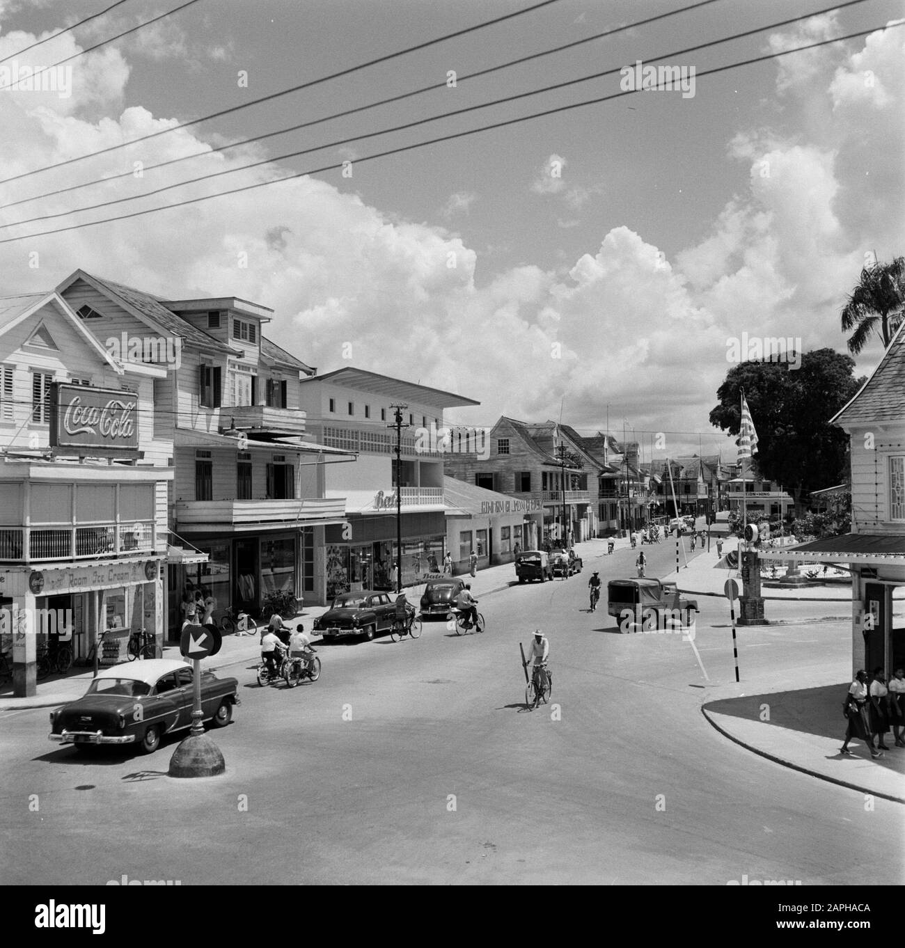 Antilles néerlandaises et Suriname au moment de la visite royale de la Reine Juliana et du Prince Bernhard en 1955 Description: Domineestraat dans le district d'Spanhoek à Paramaribo avec un magasin de chaussures Bata. A gauche un panneau publicitaire Coca-Cola Date: 1 octobre 1955 lieu: Paramaribo, Suriname mots clés: Voitures, publicité, images de rue, boutiques Nom personnel: Dominestraat, spanhoek Banque D'Images